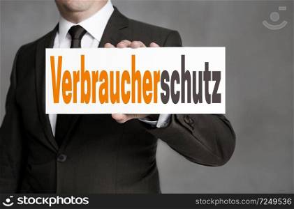 Verbraucherschutz (in german Consumer protection) sign is held by businessman.. Verbraucherschutz (in german Consumer protection) sign is held by businessman
