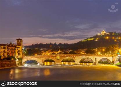 Verona, Italy - May 25, 2015: View of the Adige River, the bridge of St Peter and Leonardo hill at night.