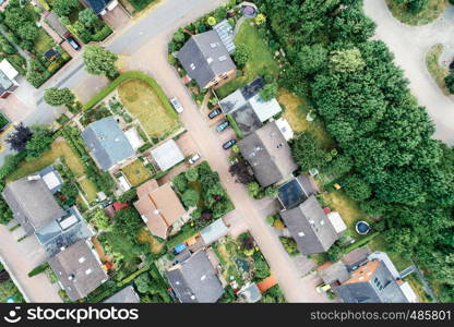 Vertical aerial view of a suburban settlement in Germany with detached houses, close neighbourhood and gardens in front of the houses, drone shot