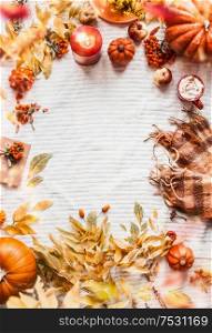 Vertical autumn background with yellow fall leaves, pumpkins, scarf, cappuccino, burning candles, apples and rowan. Top view. Cozy autumnal layout with copy space. Seasonal arrangement. Top view