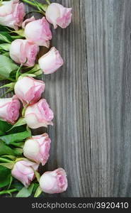 Vertical border of pink roses on a old gray boards