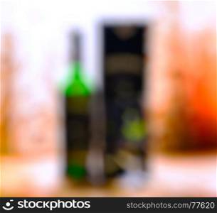 Vertical bottle of alcohol with glass and box bokeh background