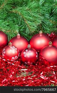 vertical Christmas still life - many red Christmas balls, tinsel on Xmas tree background