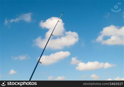 Vertical fishing rod against the blue sky
