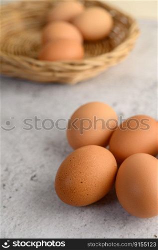 Vertical image and selective focus with Organic brown eggs several on the floor, and blurred eggs in wicker basket, preparing preparing for cooking food or dessert, copy space 
