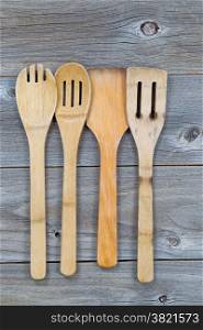 Vertical image of old wooden cooking utensils on rustic wood