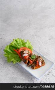 Vertical image, Selective focus appetizers with spicy sardine mixed with herb in white ceramic tray, copy space