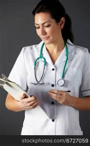 vertical,indoors,studio shot,black background,nurse,stethoscope,clipboard,pen,writing,health service,hospital,medical,healthcare,uniform,white,smiling,half length,front view,people,one person,female,woman,caucasian,adult,30s,thirties,cropped,american,usa