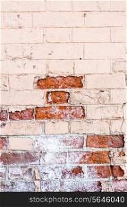 Vertical old red brick wall texture half painted.
