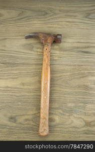 Vertical photo of an old claw hammer on aged wood