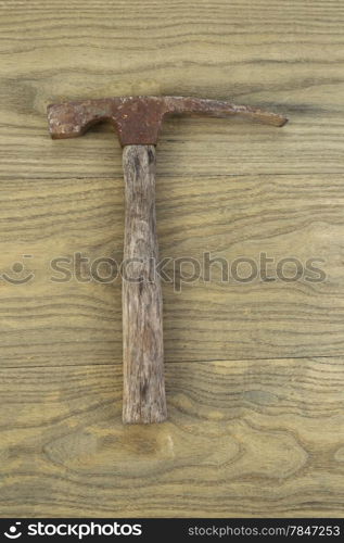 Vertical photo of an old masonry hammer on aged wood