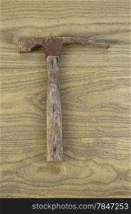 Vertical photo of an old masonry hammer on aged wood