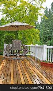 Vertical photo of outdoor patio furniture put away due to poor weather. Heavy rain on cedar wood deck.