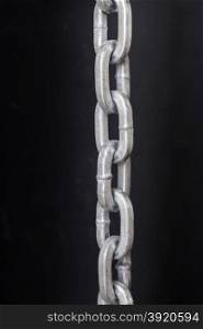 vertical picture with part of metal chrome chain against dark background