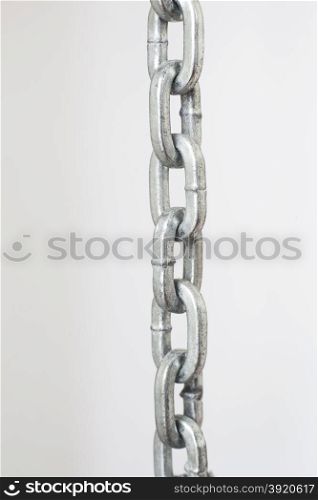 vertical picture with part of metal chrome chain against light grey background