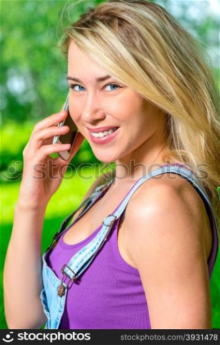 Vertical portrait of a beautiful girl with a mobile phone in hand