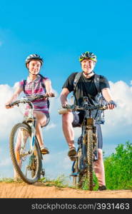 Vertical shot of a smiling couple on a bicycle