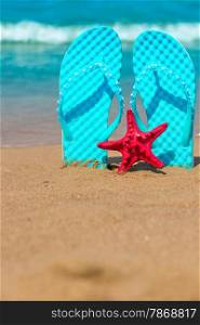 Vertical shot of beach shoes and starfish on the sea
