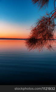 Vertical shot of calm sea waves moving towards the shore during a breathtaking sunset