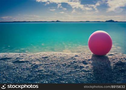 Vertical shot of pink ball at beach, clear beach at summer, clear water at sandy beach at holiday