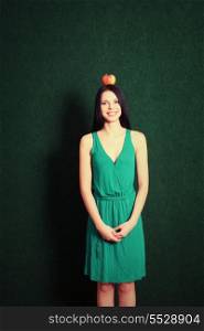 vertical shot of young female with an apple on her head
