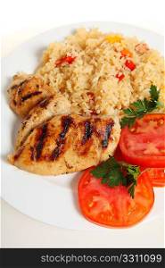 Vertical view of cajun chicken and rice with fresh sliced tomato and parsley