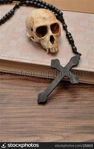 Vervet monkey skull with rosary beads on top of an old book