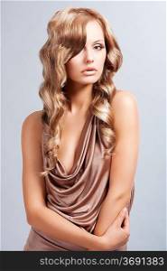 very beautiful and attractive young woman with long blonde hair in elegant silk dress and with old fashion hair style