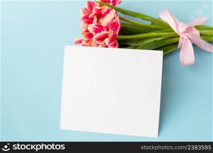 Very beautiful spring tulips on a blue paper background. Ready mokap, banner, place for an inscription. Very beautiful spring tulips on a blue paper background. Ready mokap, banner, place for an inscription.