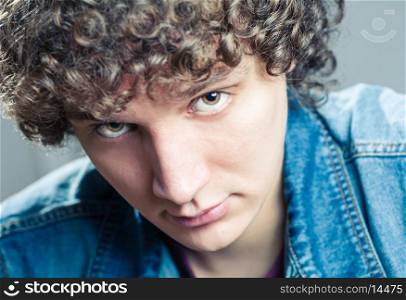 Very closeup portrait of a young caucasian guy with curly hair