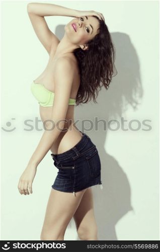 very cute and sexy young woman wearing jeans shorts and swimsuit green bra in a summer day, i fashion pose