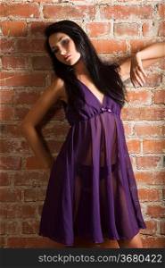 very cute asian fashion model wearing purple nightgown against a brick wall