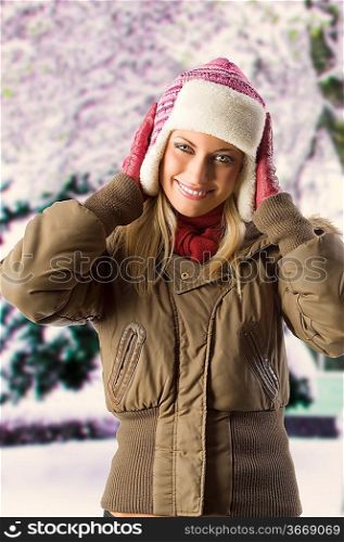 very cute blond girl wearing a winter breakwind jacket scarf gloves and pink hat