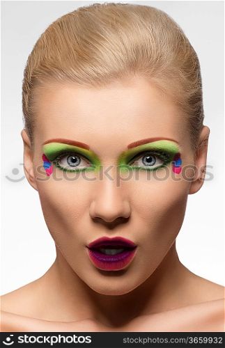 very cute blond woman with color makeup, looking in camera with expression of surprise
