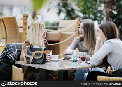 very cute smiling women drinking a coffee sitting inside in cafe restaurant