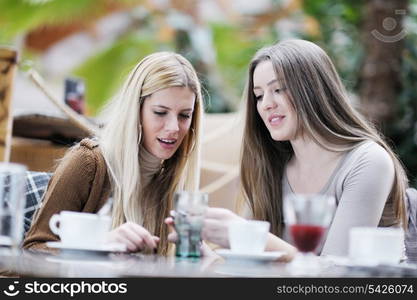 very cute smiling women drinking a coffee sitting inside in cafe restaurant