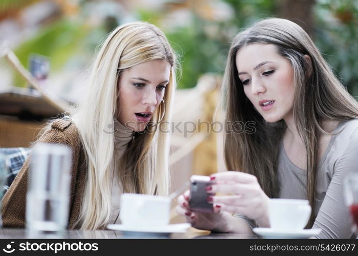 very cute smiling women drinking a coffee sitting inside in cafe restaurant