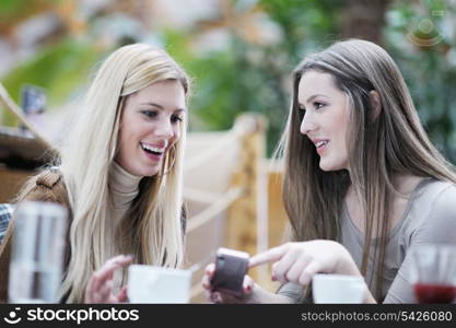 very cute smiling women drinking a coffee sitting inside in cafe restaurant