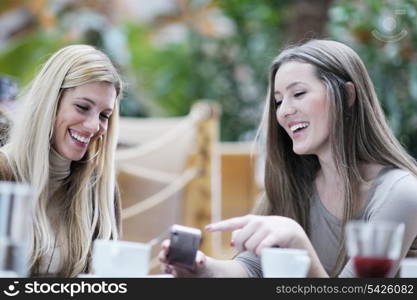 very cute smiling women drinking a coffee sitting inside in cafe restaurant