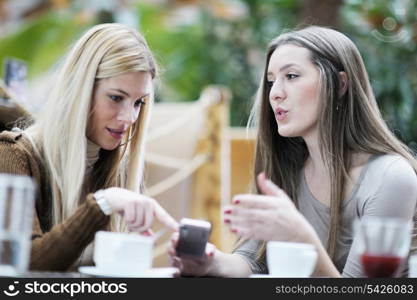 very cute smiling women drinking a coffee sitting inside in cafe restaurant