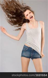 very cute young girl in casual dress screaming with her long hair in wind