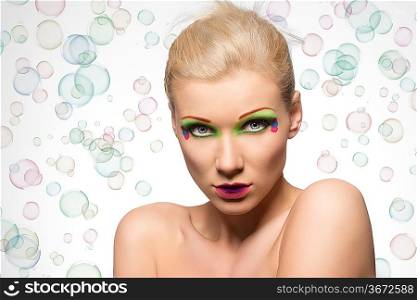 very cute young woman with creative color makeup and naked shoulder looking strong in camera