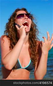 very happy beautiful woman talking by phone near the sea