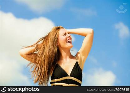 Very happy full emotions long hair woman in black on beach.