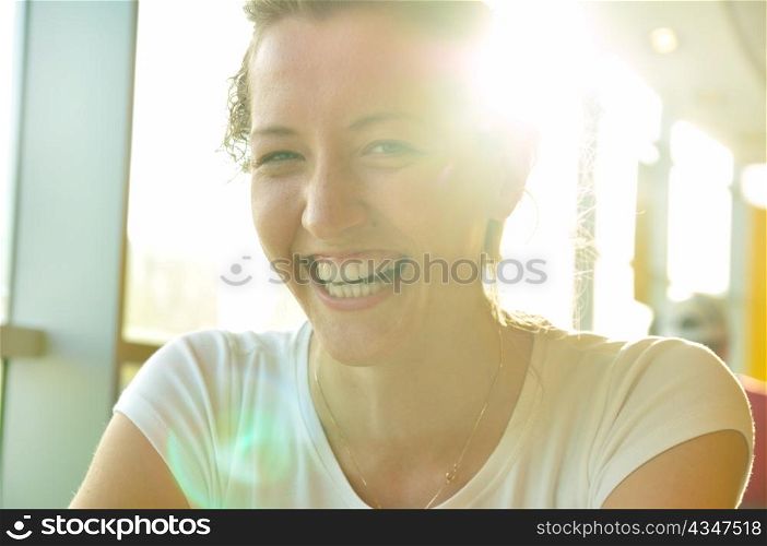 very happy woman is sitting in cafe and looking at camera