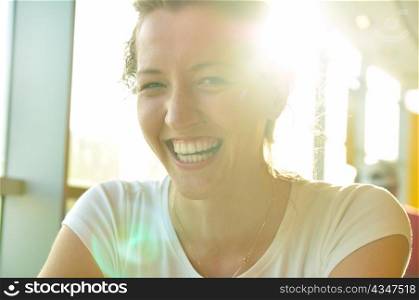 very happy woman is sitting in cafe and looking at camera