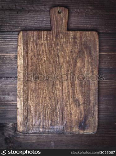 very old brown kitchen cutting board with handle, close up