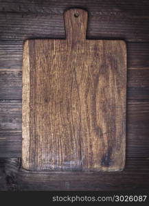 very old brown kitchen cutting board with handle, close up