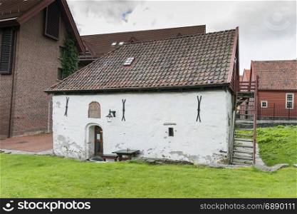 very old concrete white house build in 1666 in the village of bergen in Norway