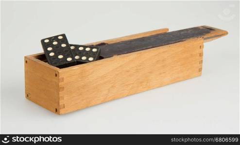 Very old domino in wooden box against the white background